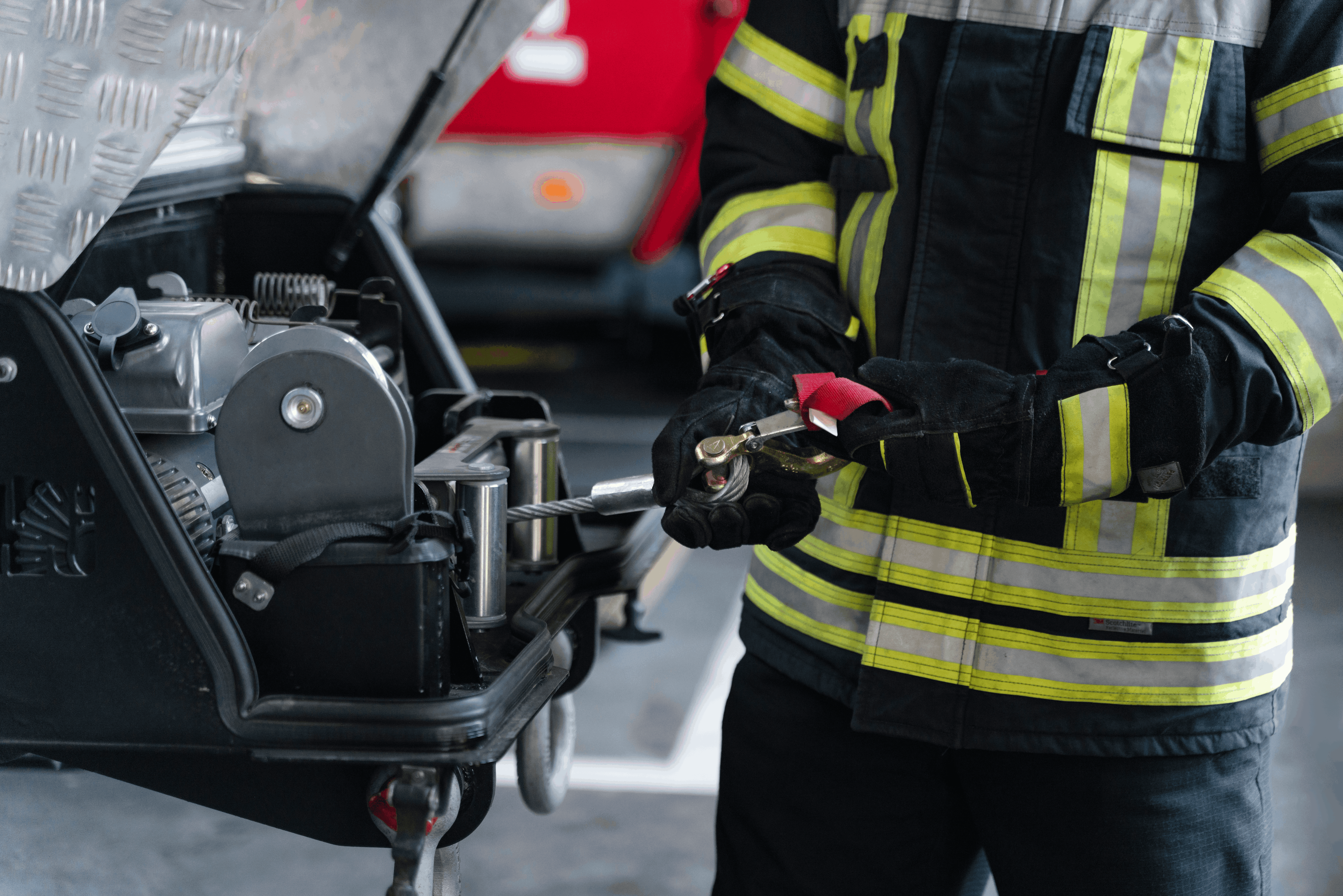 Firefighter operating emergency equipment outdoors.